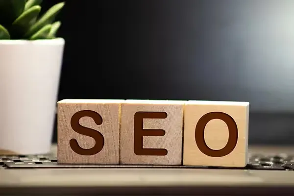Cubes en bois formant le mot SEO sur un bureau, illustration d'un audit SEO de site internet.
