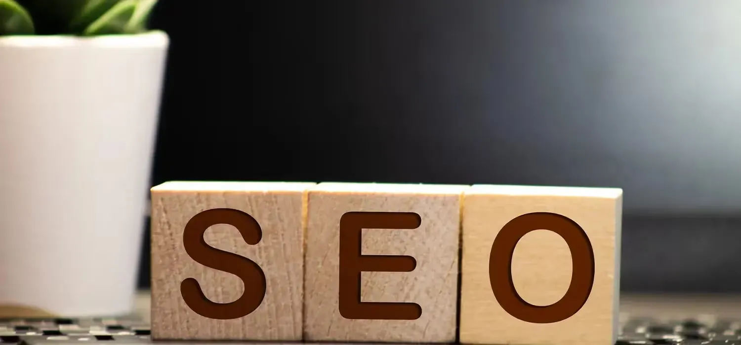 Cubes en bois formant le mot SEO sur un bureau, illustration d'un audit SEO de site internet.